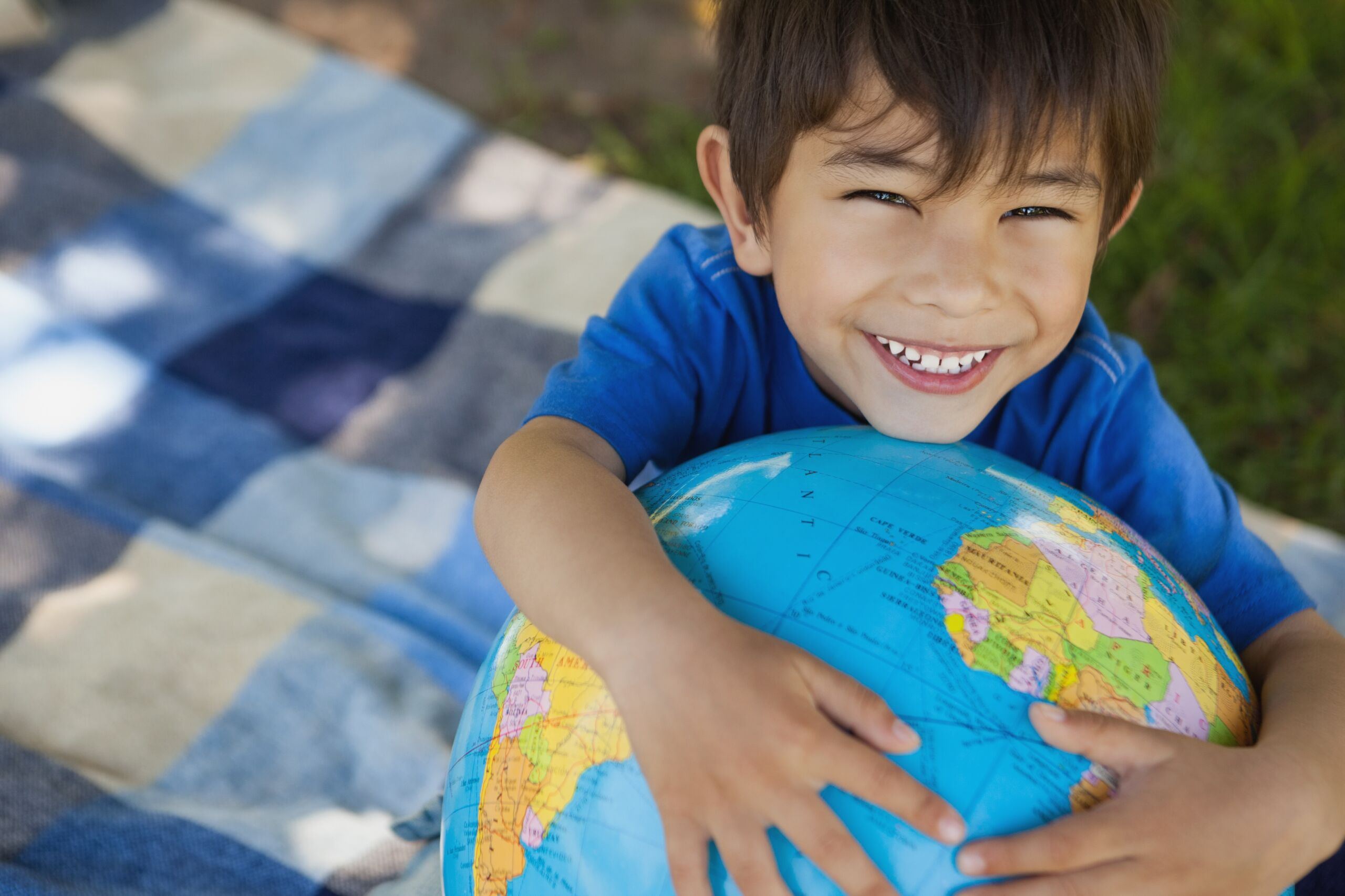 Close-up portrait of a cute boy holding globe